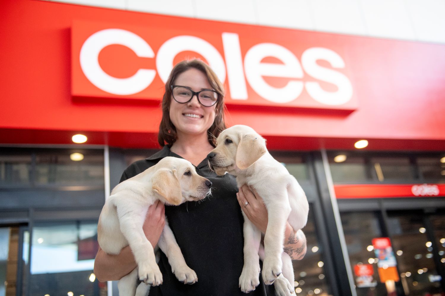 Guide Dogs trainer Chelsea with puppies in training Fergie and Idle